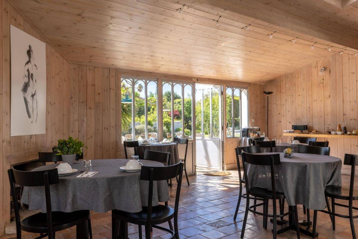 une salle à manger avec tables, chaises et fenêtres dans l'établissement Le Chat Botté, à Saint-Clément-des-Baleines 35 autres photos