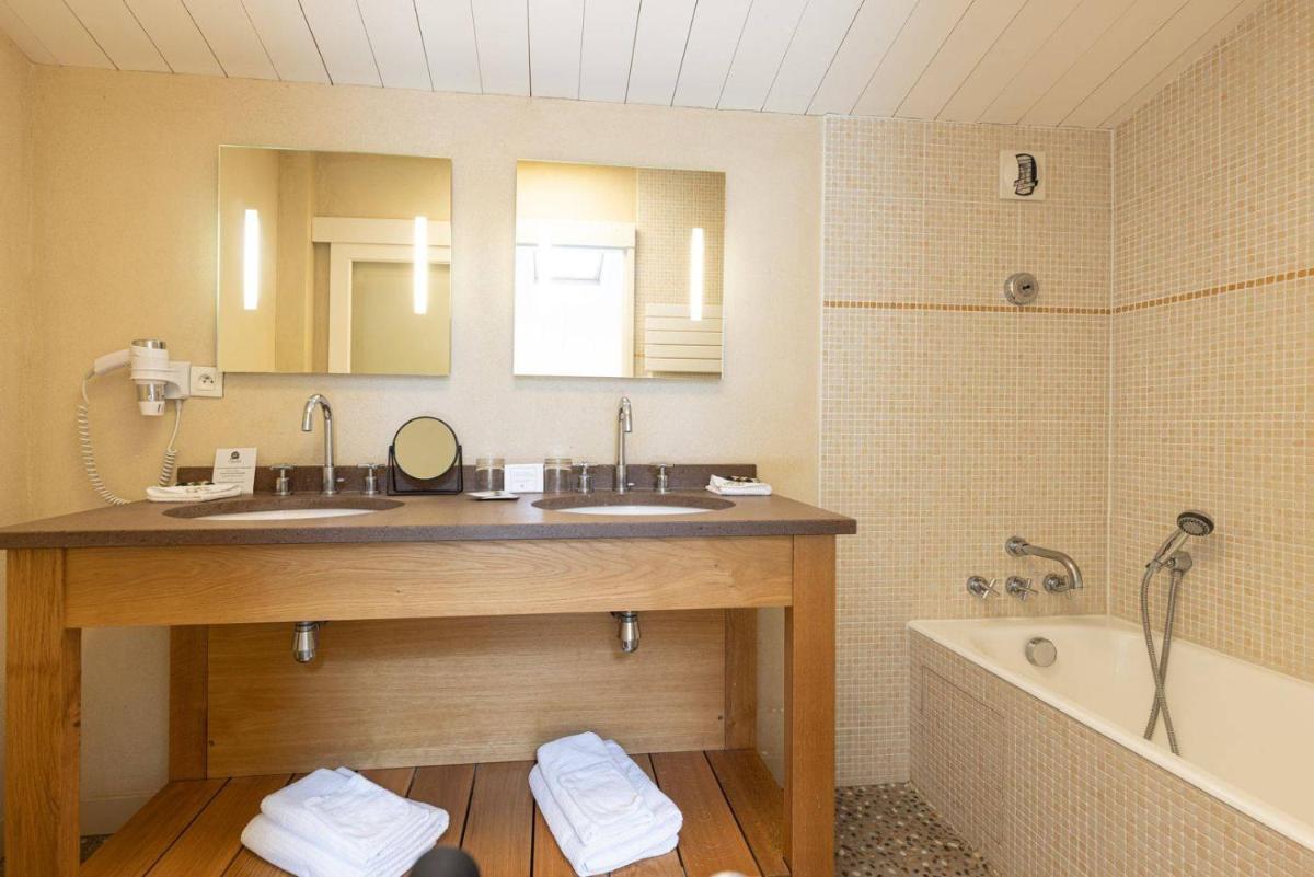 une salle de bain avec deux lavabos et une baignoire dans l'établissement Le Chat Botté, à Saint-Clément-des-Baleines