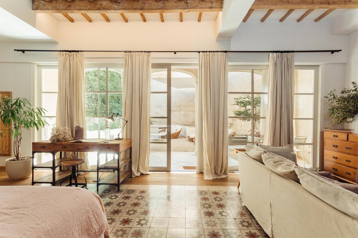 un dormitorio con una cama y un escritorio en Jardí de Ses Bruixes Boutique Hotel, en Mahón