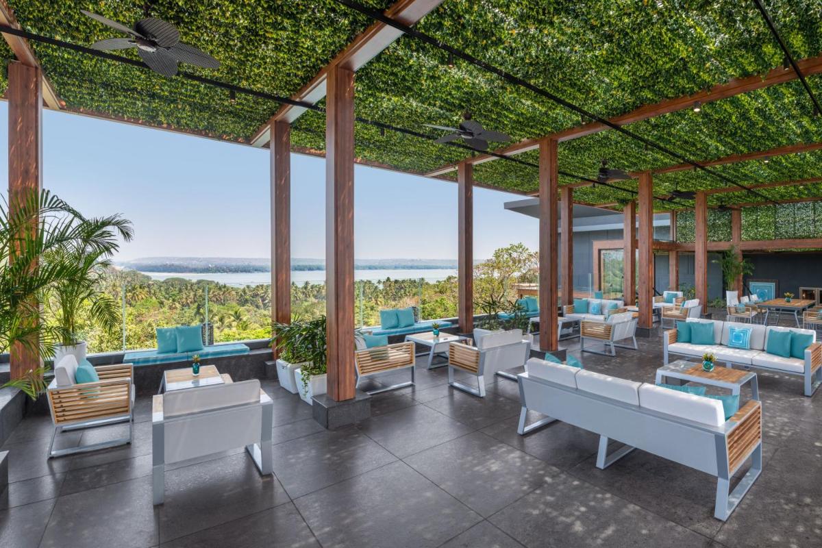 a pavilion with chairs and tables with a view at JW Marriott Goa in Vagator a pavilion with chairs and tables with a view at JW Marriott Goa in Vagator