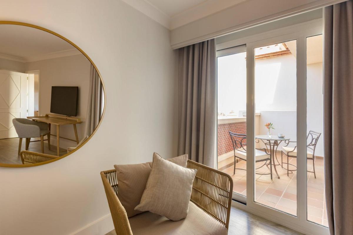 sala de estar con espejo y sofá en Denia Marriott La Sella Golf Resort & Spa, en Denia
