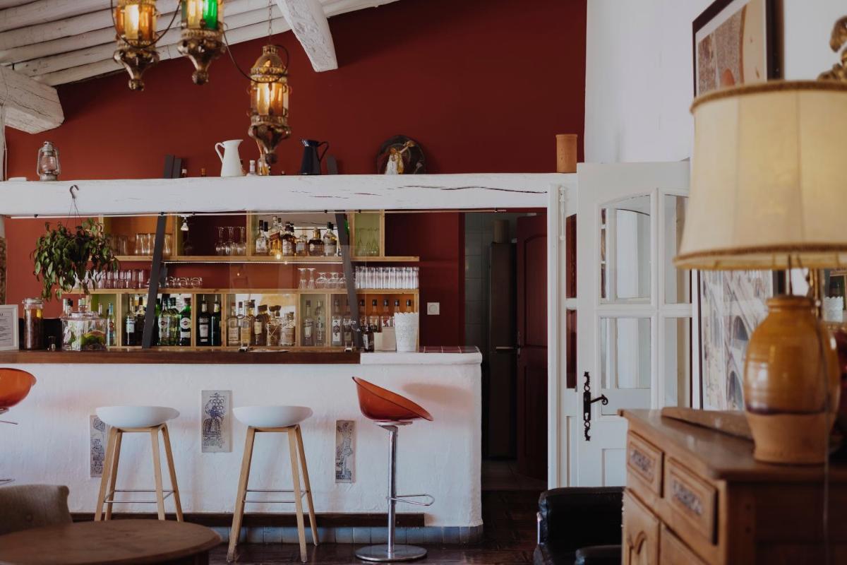 un bar avec deux tabourets dans une pièce dans l'établissement Oustau Camarguen Hôtel & Spa, au Grau-du-Roi
