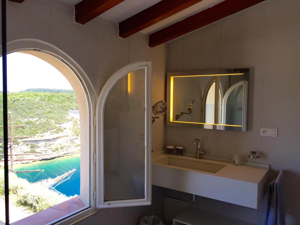 une salle de bain avec un lavabo, un miroir et une fenêtre dans l'établissement Hotel Spa Genovese, à Bonifacio