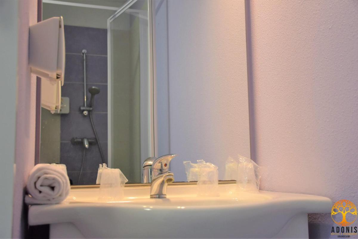 une salle de bains avec un lavabo et un miroir dans l'établissement Adonis Grandcamp - Résidence Les Isles De Sola, à Grandcamp-Maisy