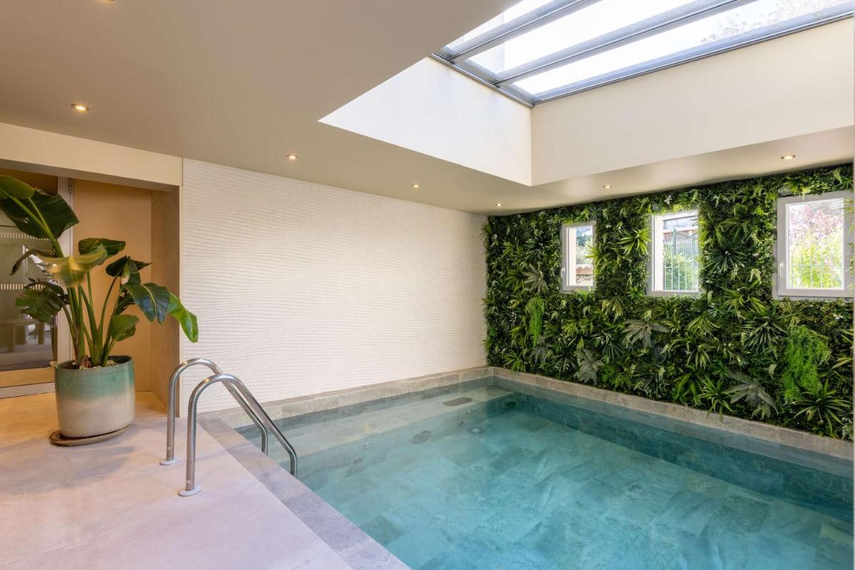 - une piscine dans une maison dotée d'un mur vert dans l'établissement Best Western Hotel & SPA Coeur De Cassis, à Cassis