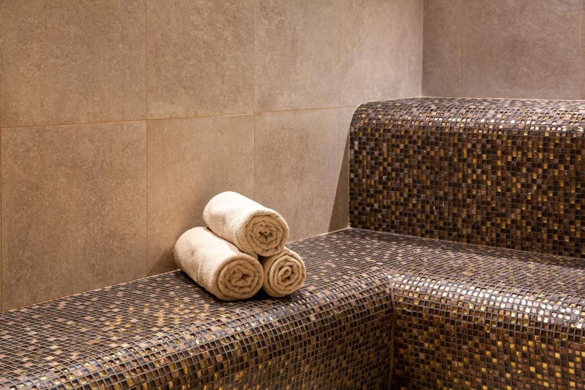 - deux serviettes laminées assises sur un banc dans une salle de bains dans l'établissement Best Western Hotel & SPA Coeur De Cassis, à Cassis