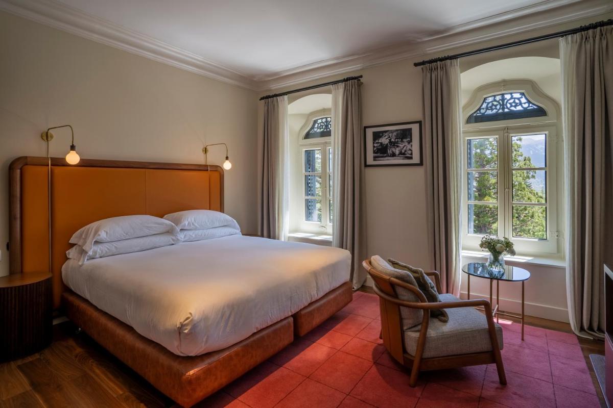 Un dormitorio con una cama y una silla y ventanas. en Torre del Remei, en Bolvir
