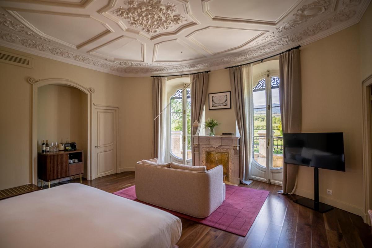 Un dormitorio con una cama, un sofá y un televisor. en Torre del Remei, en Bolvir