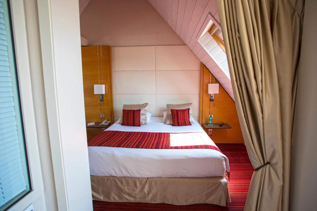 Un ou plusieurs lits dans un hébergement de l'établissement Le Churchill Hôtel & Spa
