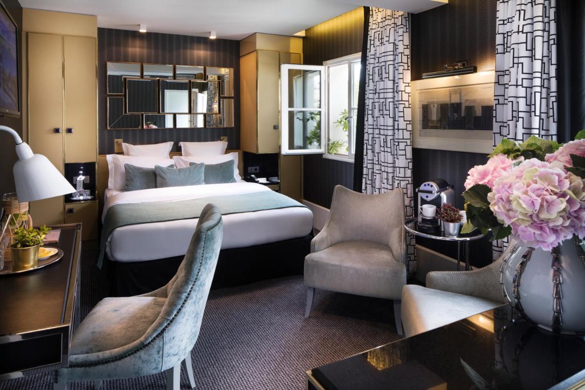 une chambre d'hôtel avec un lit et un bureau dans l'établissement Hôtel Baume, à Paris
