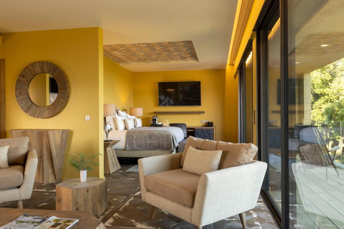 un salon aux murs jaunes et une chambre dans l'établissement Les Regalia Hôtel & Spa, à Sainte-Lucie de Porto-Vecchio