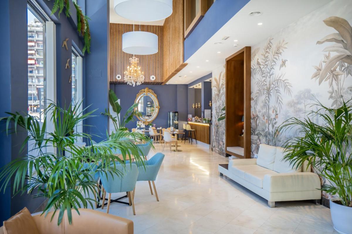 Un vestíbulo con paredes azules y plantas en macetas. en Hotel Spa Cádiz Plaza, en Cádiz