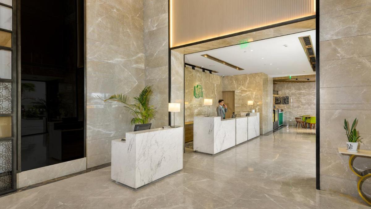 a lobby with a row of white reception desks at Holiday Inn Gurugram Sector 90 by IHG in Gurgaon