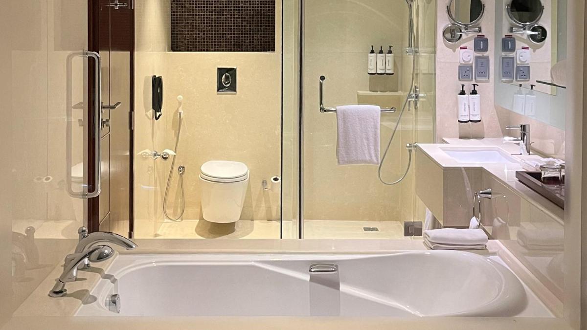 a bathroom with a tub and two sinks and a shower at Crowne Plaza Kochi by IHG in Cochin