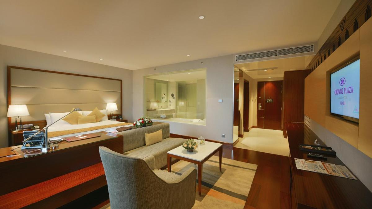 a living room with a couch and a bed and a television at Crowne Plaza Kochi by IHG in Cochin