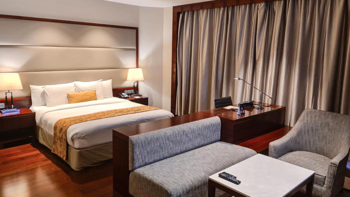 a hotel room with a bed and a desk at Crowne Plaza Kochi by IHG in Cochin