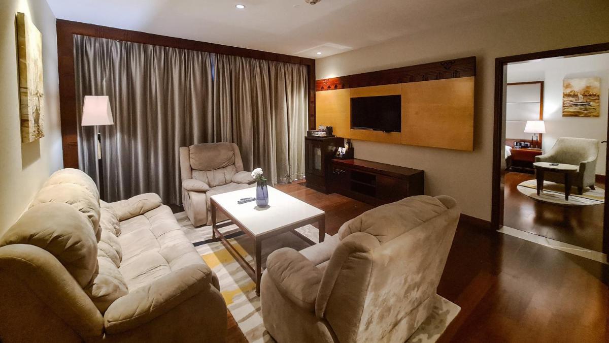 a living room with two couches and a television at Crowne Plaza Kochi by IHG in Cochin