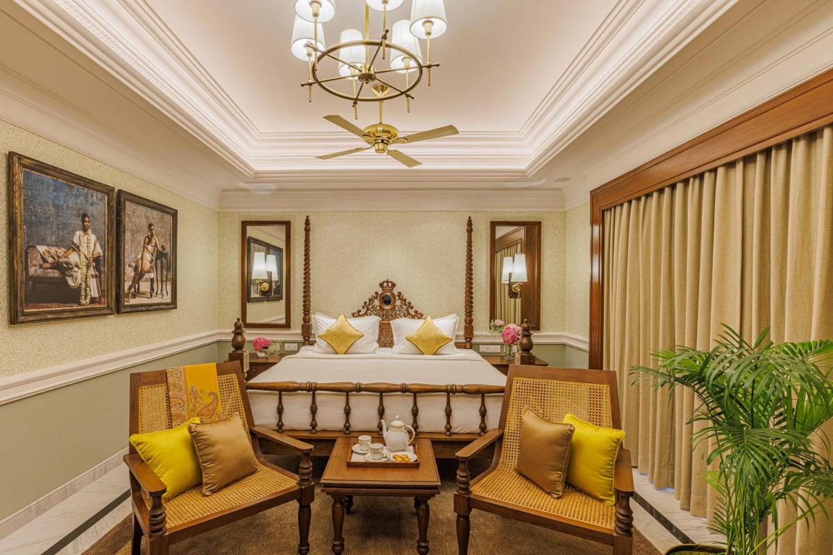 a bedroom with a bed and two chairs at Raajkutir - IHCL SeleQtions in Kolkata