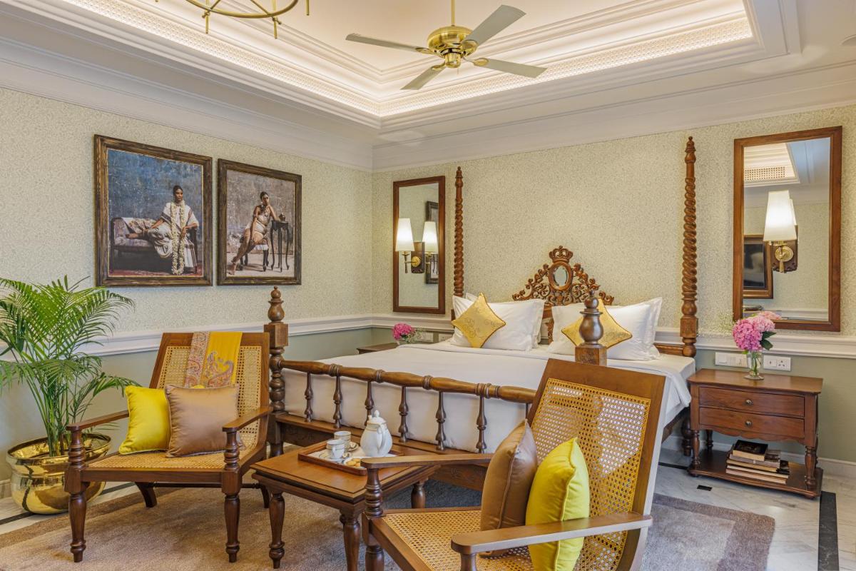 a bedroom with a large bed and two chairs at Raajkutir - IHCL SeleQtions in Kolkata