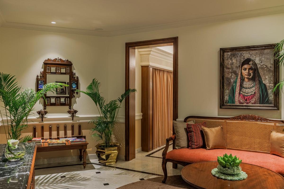 a living room with a couch and a portrait of a woman at Raajkutir - IHCL SeleQtions in Kolkata