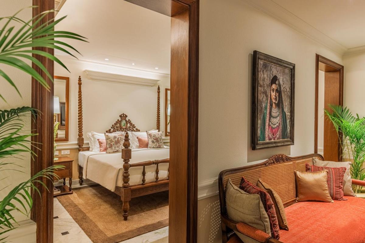 a bedroom with a bed and a mirror at Raajkutir - IHCL SeleQtions in Kolkata