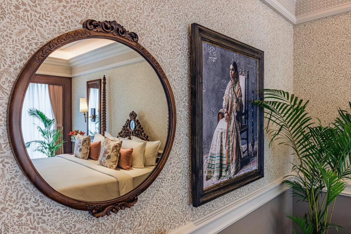 a mirror on a wall with a bed in a room at Raajkutir - IHCL SeleQtions in Kolkata