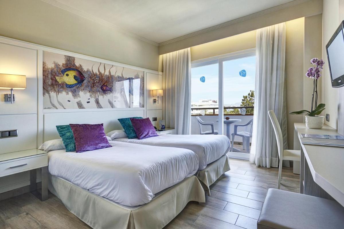 Una habitación de hotel con dos camas y balcón. en Grupotel Maritimo, en Puerto de Alcudia