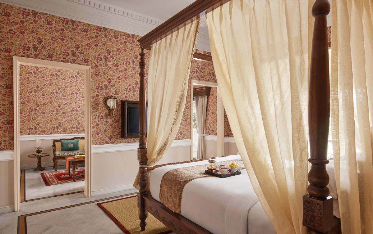 a bedroom with a canopy bed and a mirror at Raajkutir - IHCL SeleQtions in Kolkata