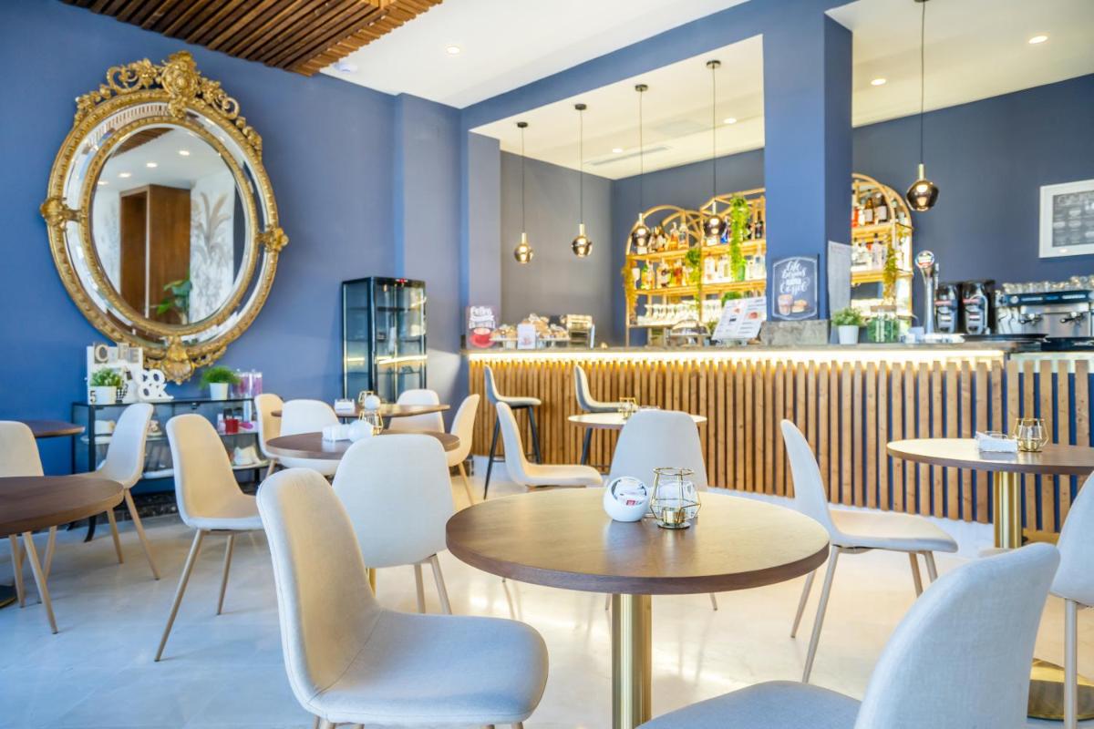 Un restaurante con paredes azules, mesas y sillas. en Hotel Spa Cádiz Plaza, en Cádiz