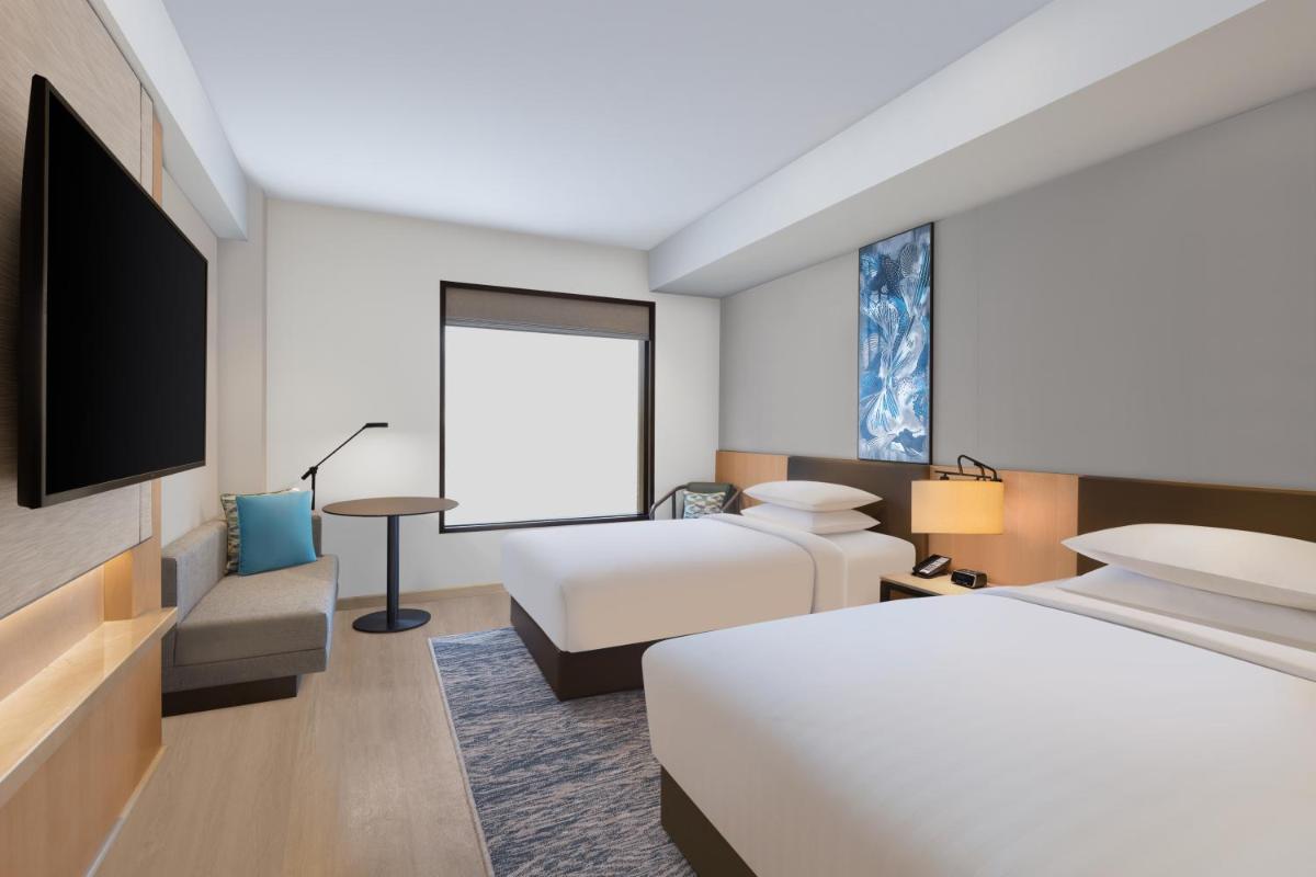 a hotel room with two beds and a flat screen tv at Fairfield by Marriott Dehradun in Dehradun