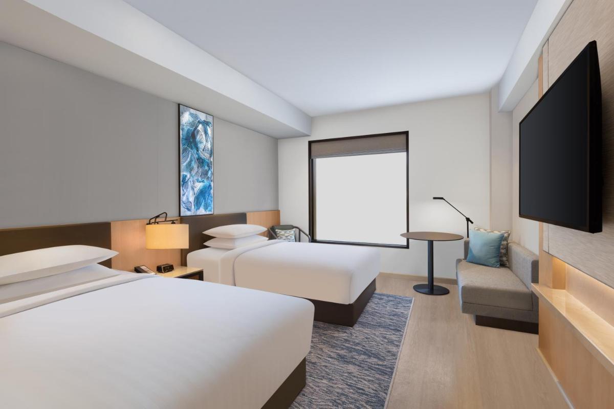 a hotel room with a bed and a flat screen tv at Fairfield by Marriott Dehradun in Dehradun