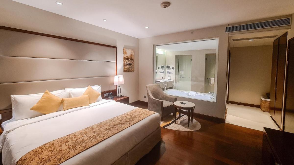 a hotel room with a bed and a bathroom at Crowne Plaza Kochi by IHG in Cochin