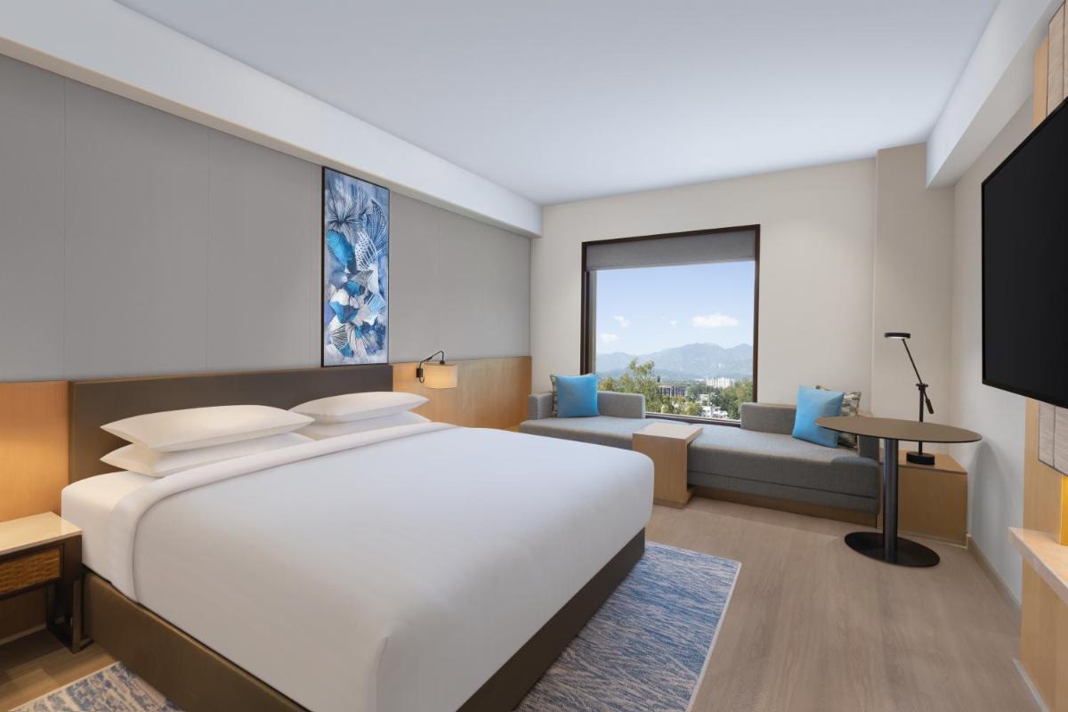 a bedroom with a large white bed and a couch at Fairfield by Marriott Dehradun in Dehradun