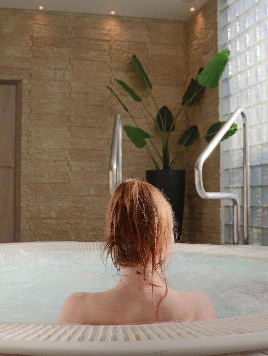 une femme dans une baignoire avec une plante dans l'établissement Quintessia, à Orvault