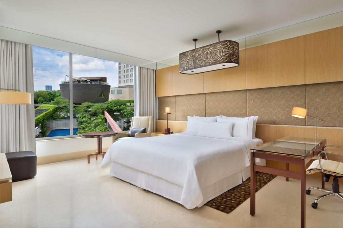 a bedroom with a large white bed and a desk at The Westin Gurgaon, New Delhi in Gurgaon