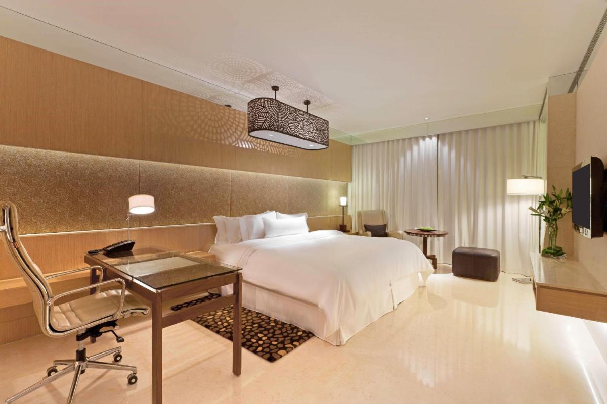 a hotel room with a bed and a desk and a chair at The Westin Gurgaon, New Delhi in Gurgaon