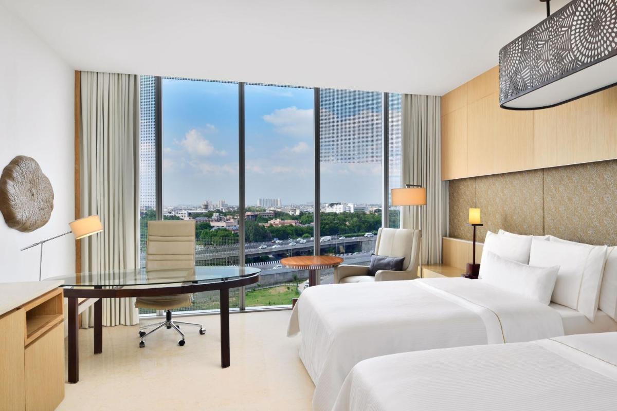 a hotel room with two beds and a desk at The Westin Gurgaon, New Delhi in Gurgaon