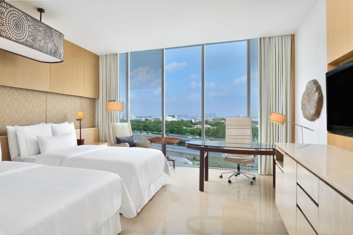 a hotel room with two beds and a desk at The Westin Gurgaon, New Delhi in Gurgaon