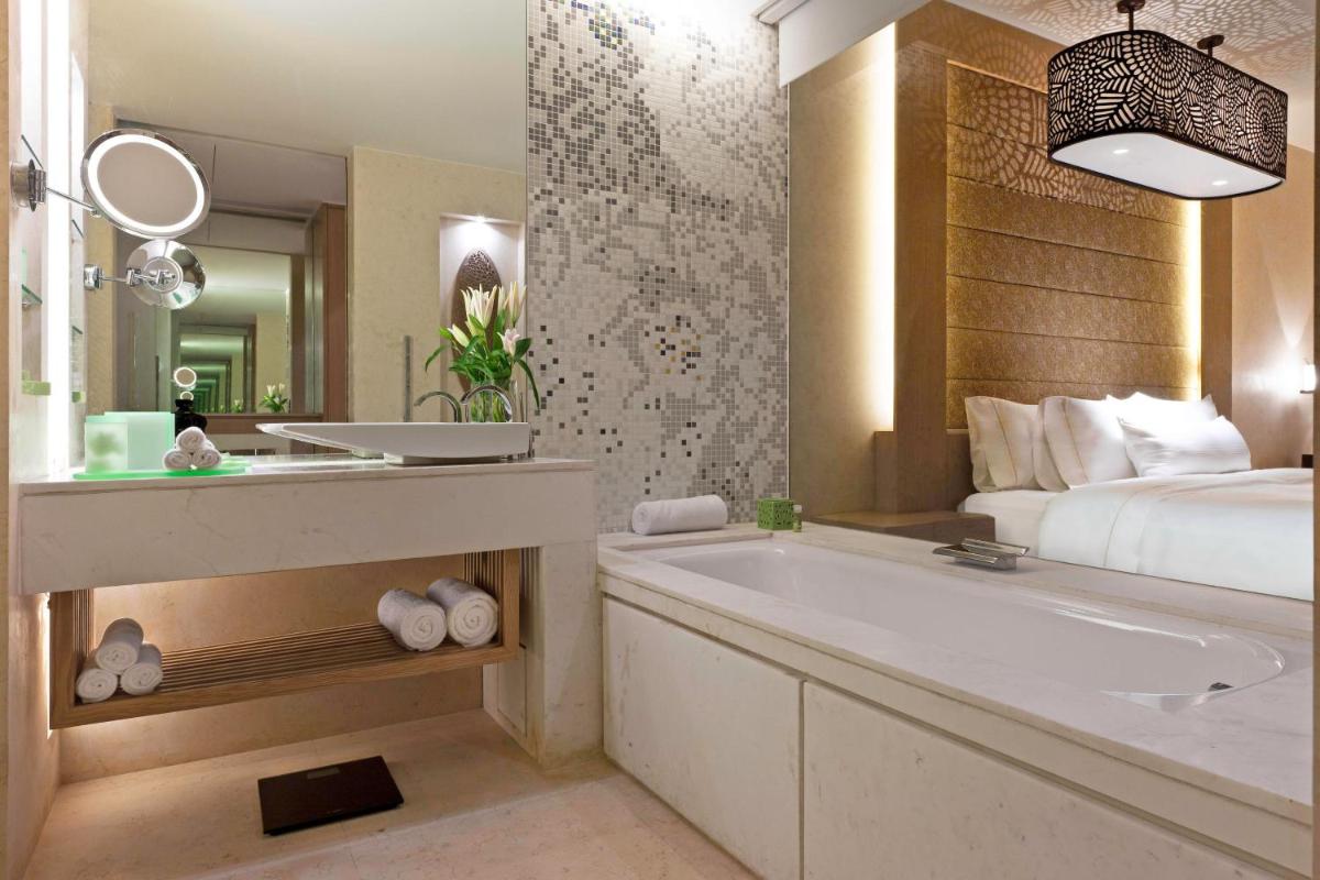 a bathroom with a tub and a bed and a sink at The Westin Gurgaon, New Delhi in Gurgaon