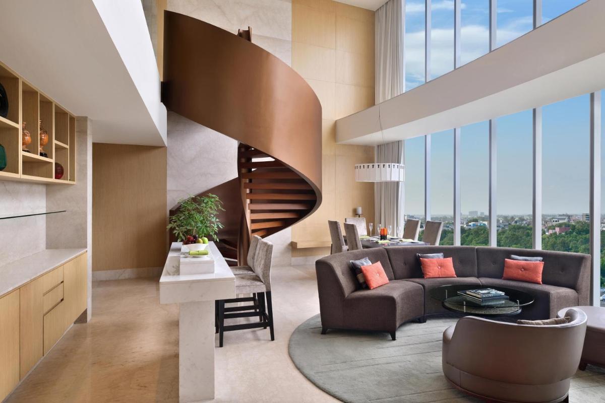 a living room with a couch and a staircase at The Westin Gurgaon, New Delhi in Gurgaon
