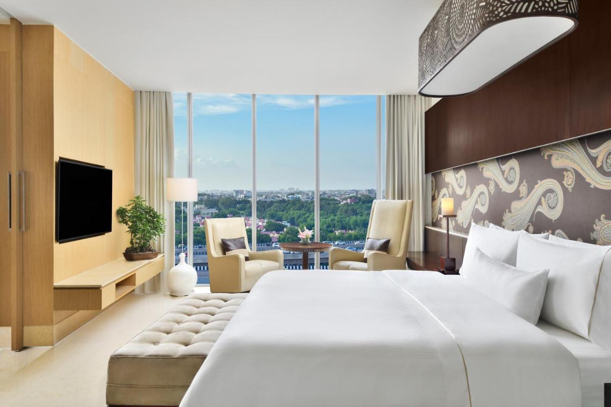 a hotel room with a large bed and a large window at The Westin Gurgaon, New Delhi in Gurgaon