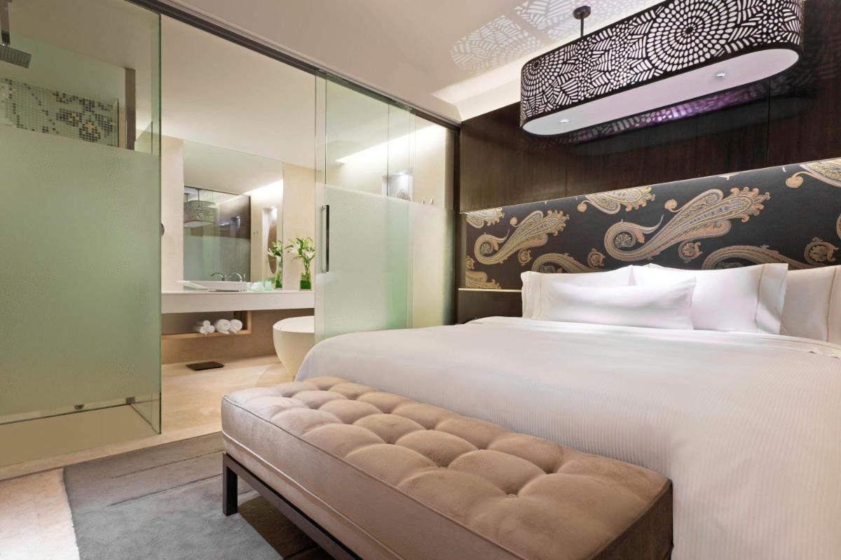 a bedroom with a large white bed and a bench at The Westin Gurgaon, New Delhi in Gurgaon