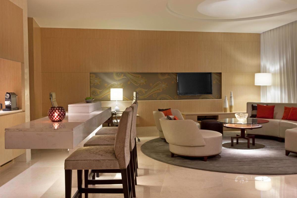 a living room with a couch and a table and chairs at The Westin Gurgaon, New Delhi in Gurgaon
