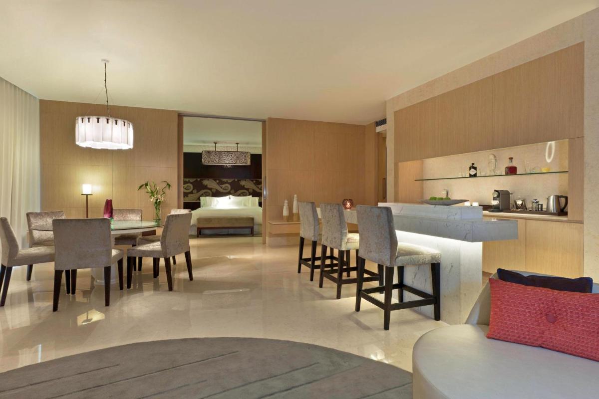 a dining room and kitchen with a dining table and chairs at The Westin Gurgaon, New Delhi in Gurgaon