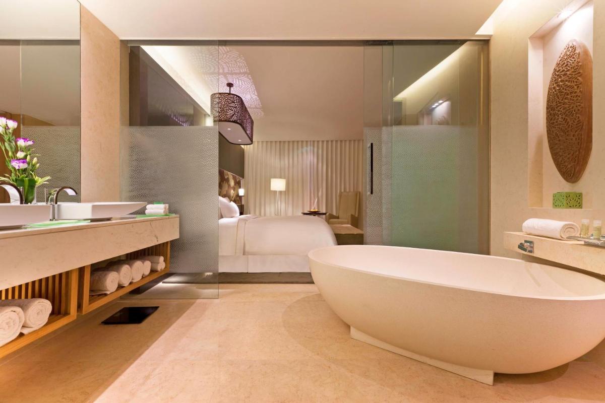 a bathroom with a large tub and a bedroom at The Westin Gurgaon, New Delhi in Gurgaon