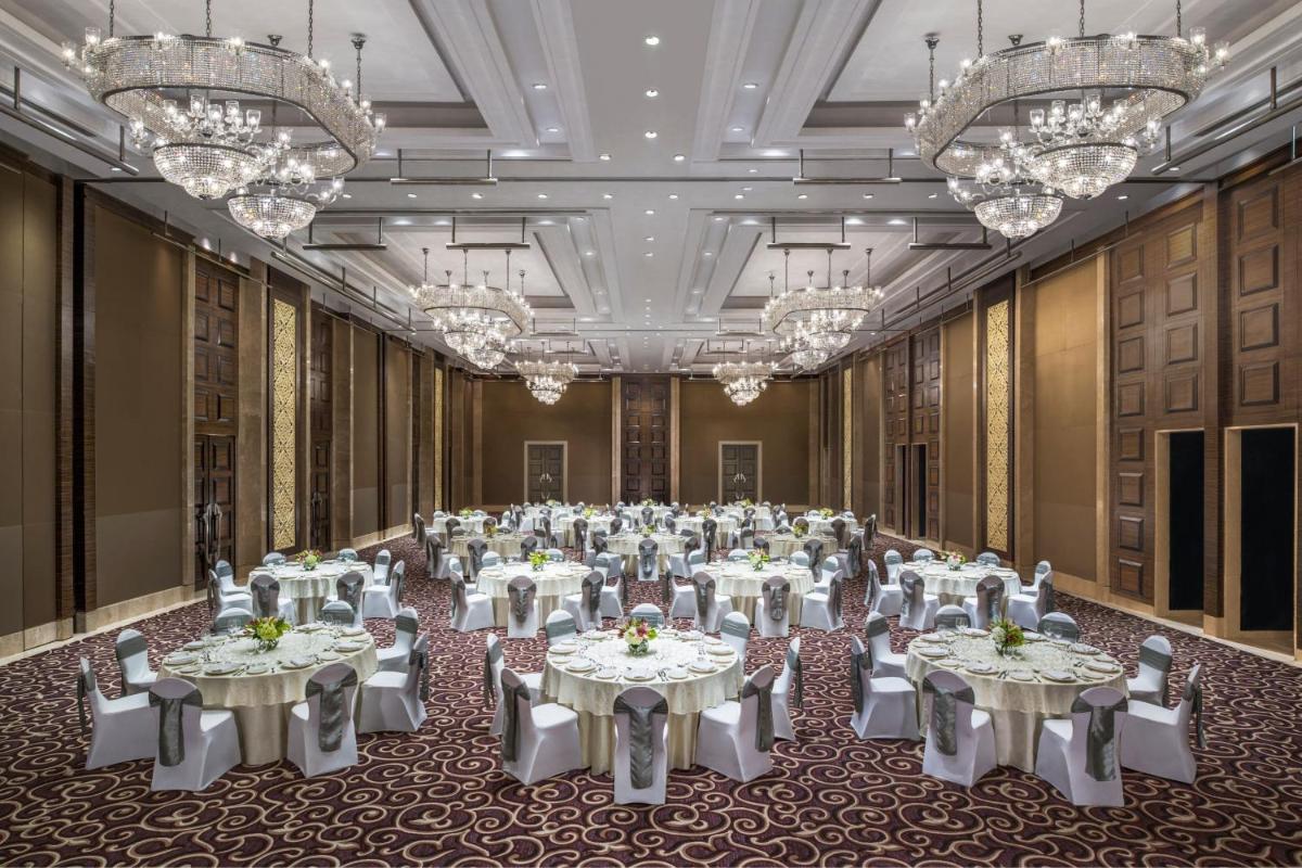 a large banquet hall with white tables and chandeliers at The St. Regis Mumbai in Mumbai