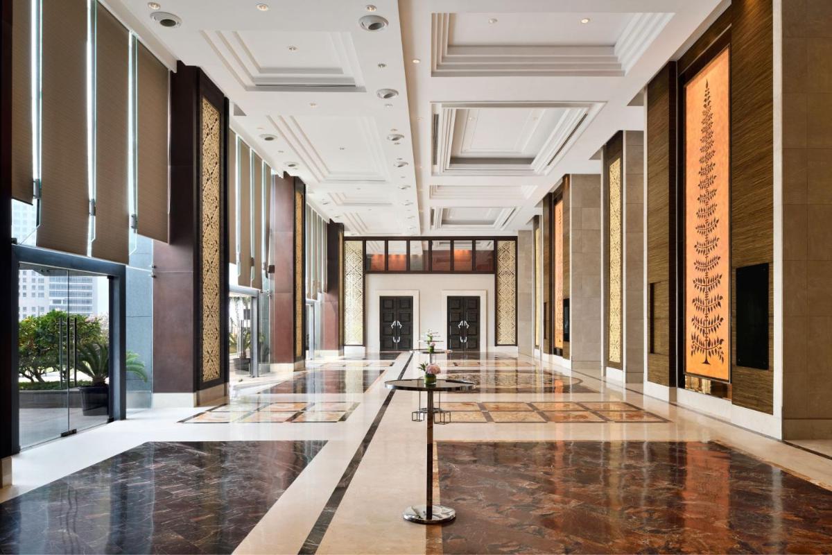a hallway of a building with a lobby with windows at The St. Regis Mumbai in Mumbai