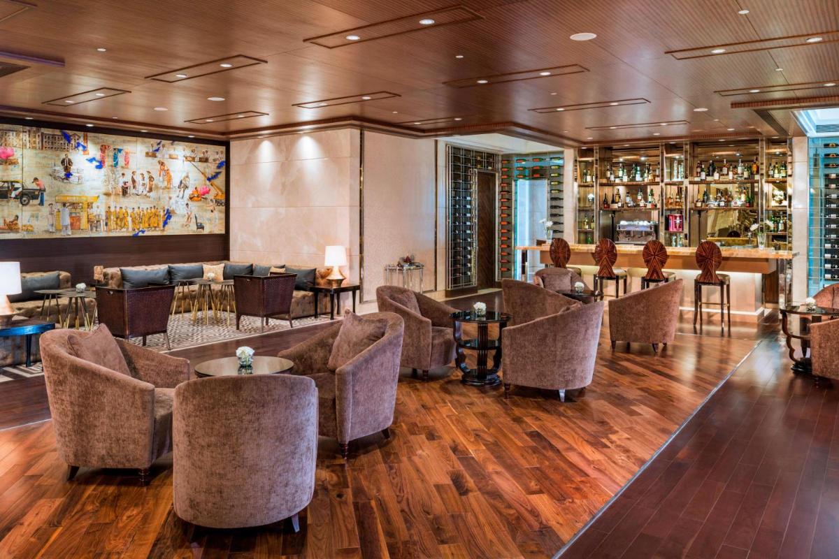a lobby of a hotel with couches and a bar at The St. Regis Mumbai in Mumbai