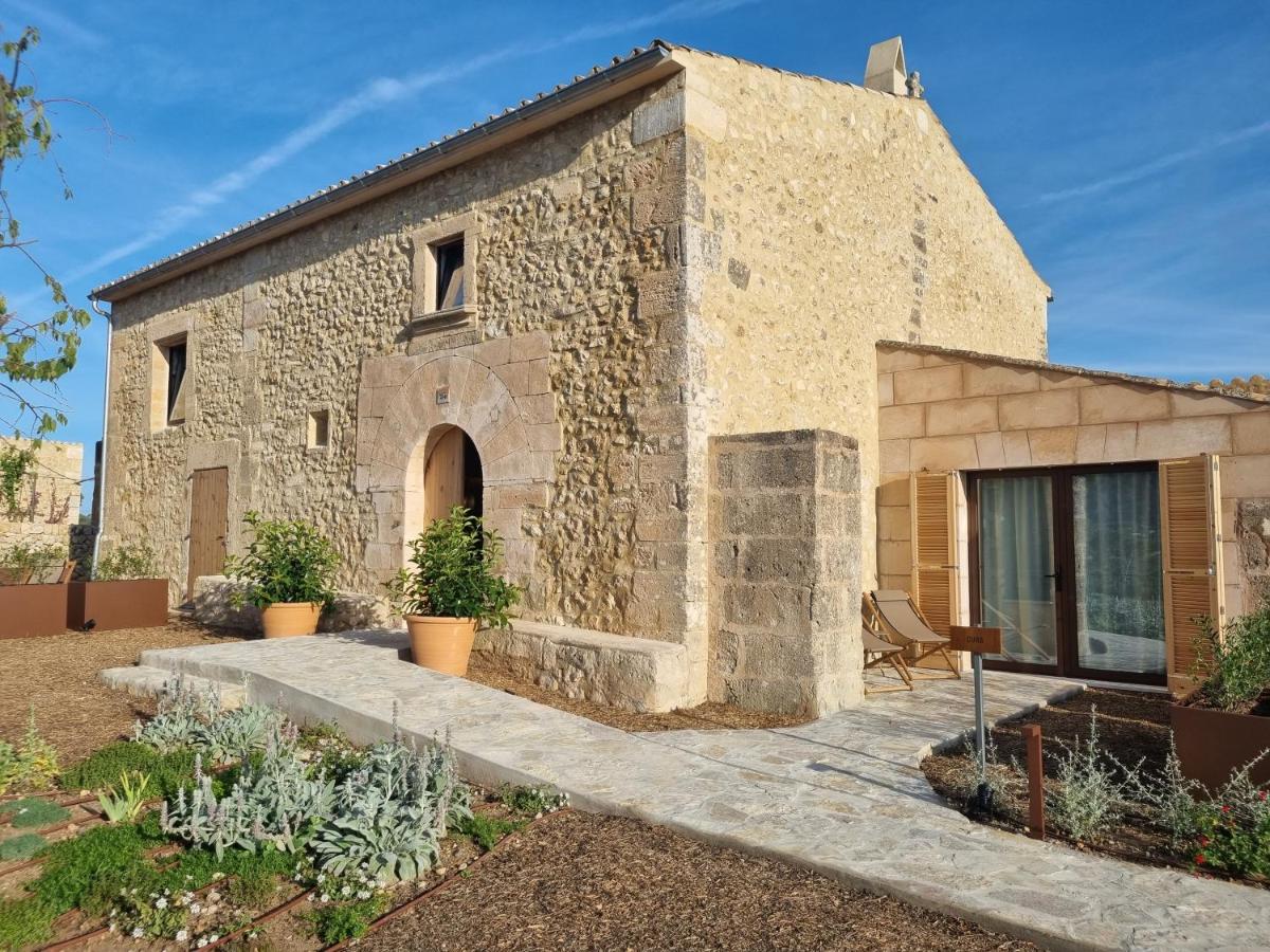 un antiguo edificio de piedra con un patio delante de él en Fincahotel Treurer - Olive Grove & Grand House - Adults Only, en Algaida