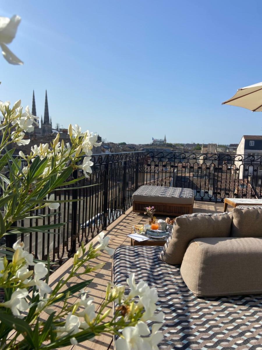 d'un balcon avec des canapés et une vue sur la ville. dans l'établissement Hôtel Singulier Bordeaux - Boutique Hôtel & Spa Anne Semonin, à Bordeaux